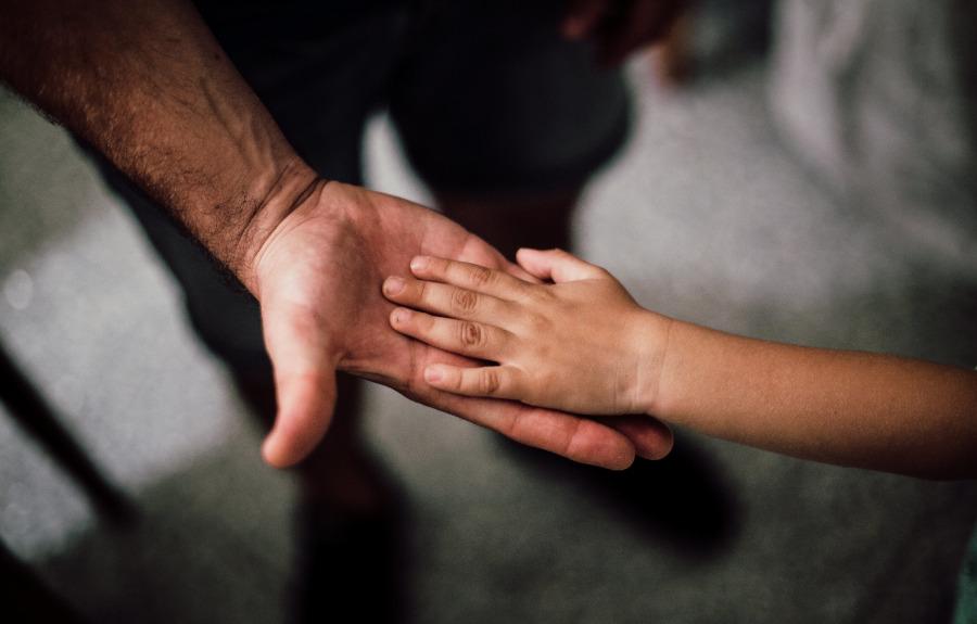 Image of father's hand and child's hand