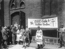 Berlin, 1933. <a href="https://en.wikipedia.org/wiki/File:Bundesarchiv_Bild_183-1985-0109-502,_Kirchenwahl.-_Propaganda_der_%22Deutschen_Christen%22_in_Berlin.jpg">Wikimedia</a>
