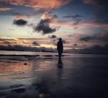Image of solitary man on a dark beach